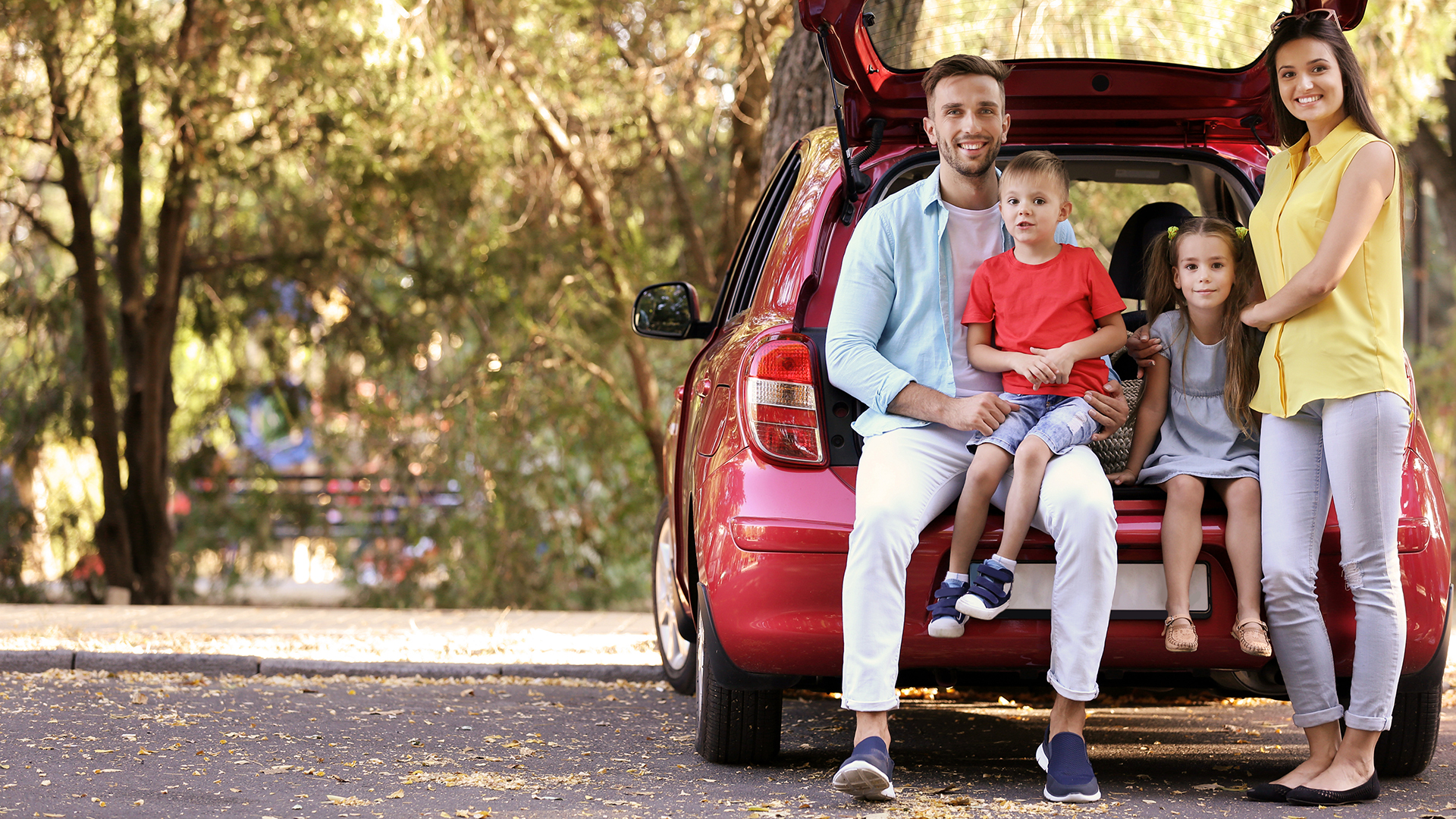 Family With Kids Sitting In Car Trunk