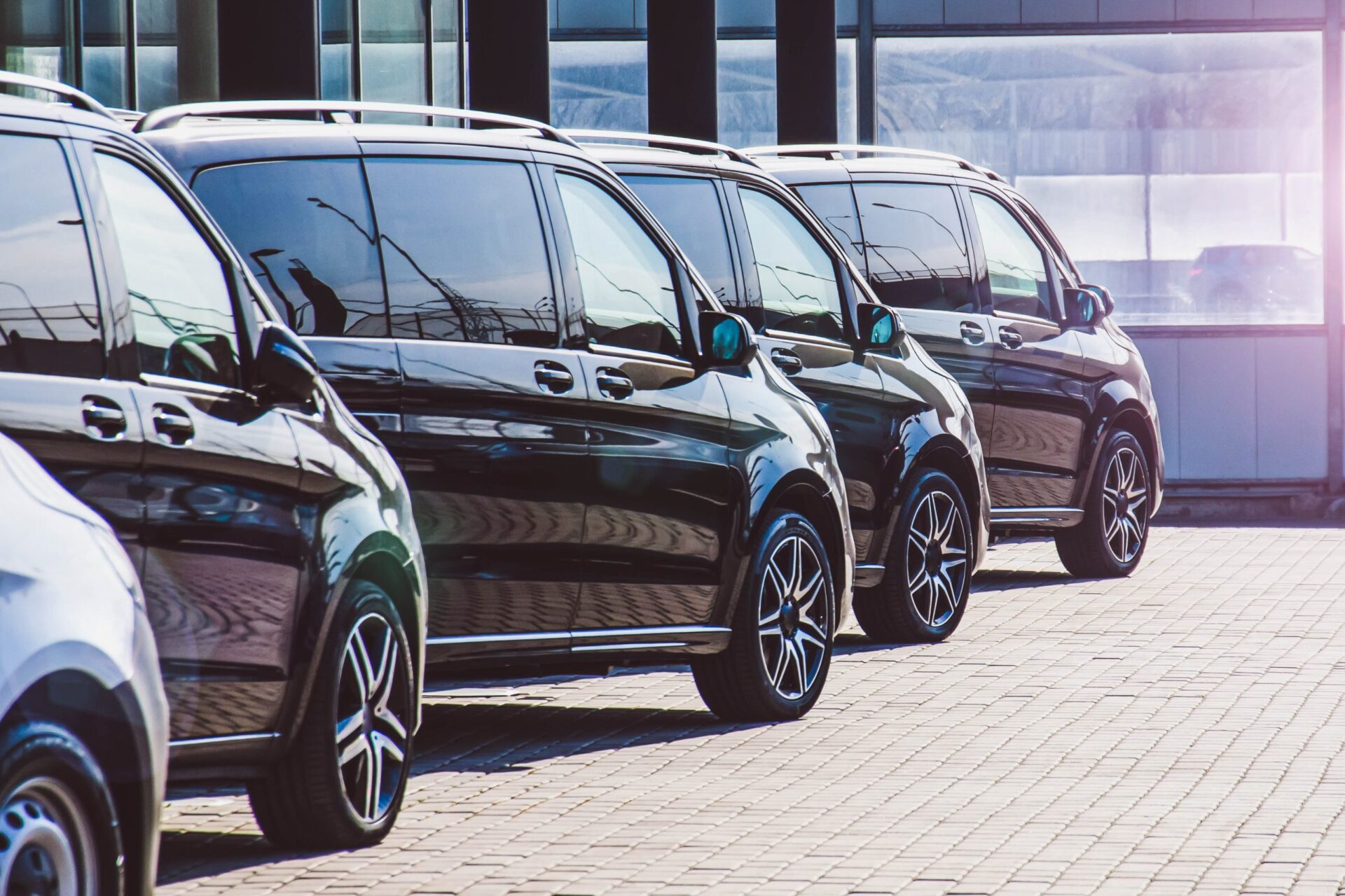Dark Colored Passenger Vans In A Parking Lot.