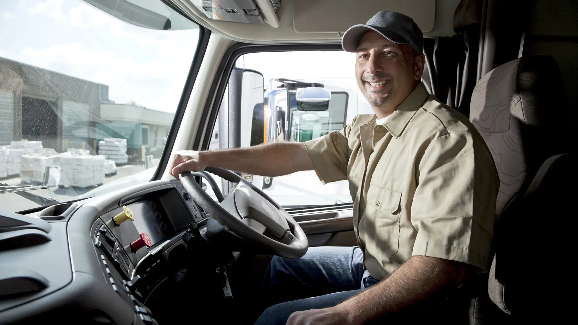 Truck Driver Sitting In Cab Of Semi Truck